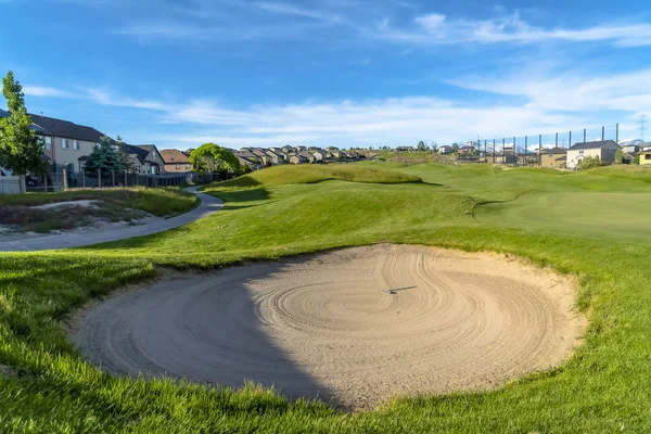 Zamknij bunkier piaskowy na polu golfowym pod błękitne niebo i chmury w słoneczny dzień — Zdjęcie stockowe