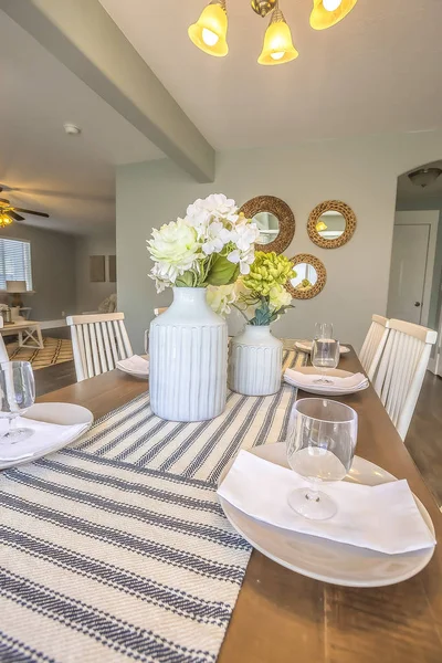 White dinnerware and table runners at the dining room of a family home