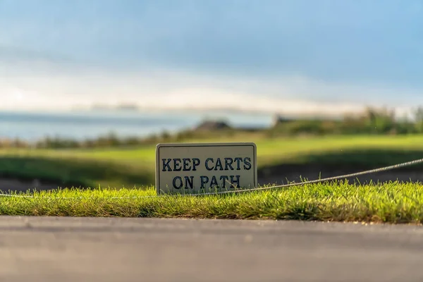 Zbliżenie znaku Keep Carts on Path obok utwardzonej ścieżki pola golfowego — Zdjęcie stockowe