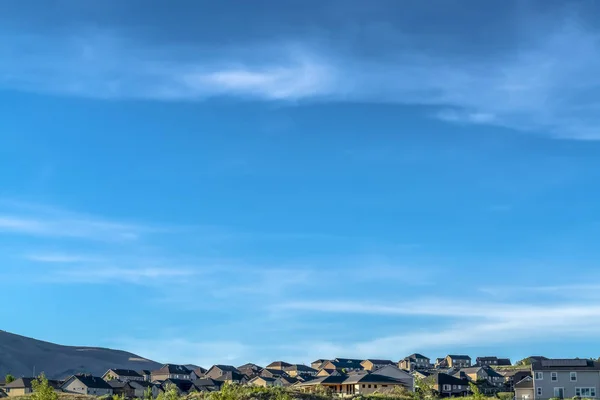 Mooie huizen in een buurt met stralende blauwe hemel en wolken overhead — Stockfoto