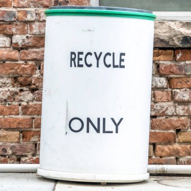 Kare Bir binanın taş tuğla duvar ve pencerelere karşı bir çöp kutusu yakın