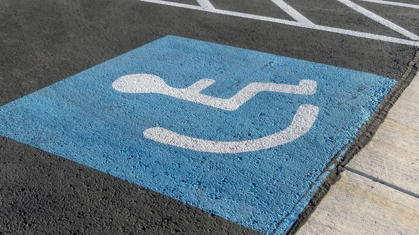 Panorama zbliżenie osoby na ikonę wózka inwalidzkiego pomalowanego na czarnym chodniku — Zdjęcie stockowe