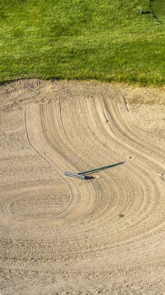 Marco vertical Primer plano del campo de golf bunker de arena con un patrón circular creado por el rastrillo —  Fotos de Stock