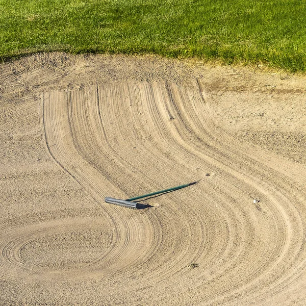 Vierkant frame close-up van golfbaan zand bunker met een cirkelvormig patroon gecreëerd door de rake — Stockfoto