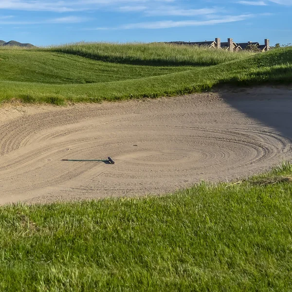 Čtvercový rám golfové hřiště s písečným bunkru a pulzující plavnou cestou pod modrou oblohou za slunečného dne — Stock fotografie