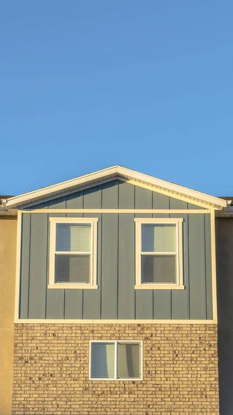 Vertical Vista de cerca del exterior de la casa adosada iluminada por el sol con fondo de cielo azul claro — Foto de Stock