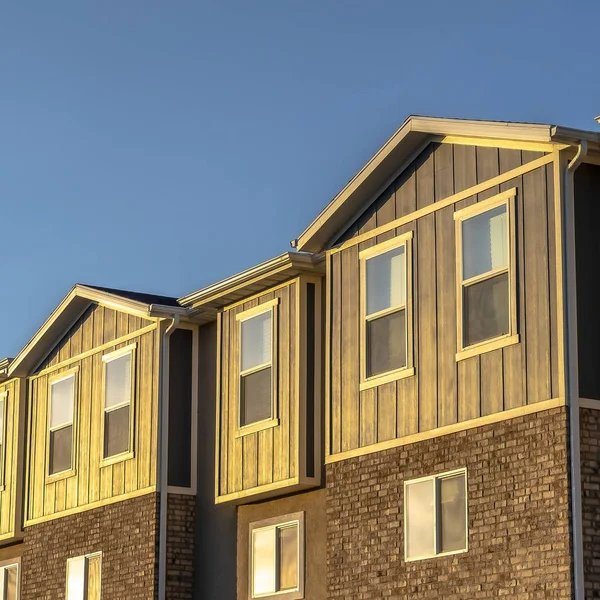 Casas adosadas de marco cuadrado con combinación de ladrillo de madera y pared de hormigón en un día soleado — Foto de Stock