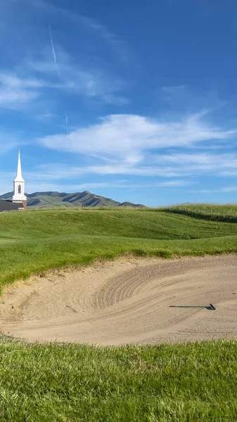 Vertical frame Golf course with sand bunker and vibrant fairway under blue sky on a sunny day — Stock Photo, Image