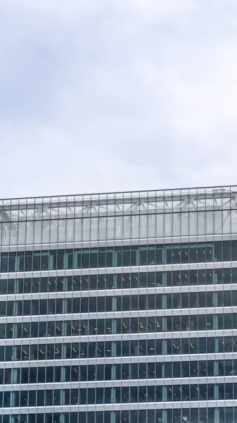 Marco vertical Vista exterior de un edificio con diseño arquitectónico moderno contra el cielo nublado — Foto de Stock