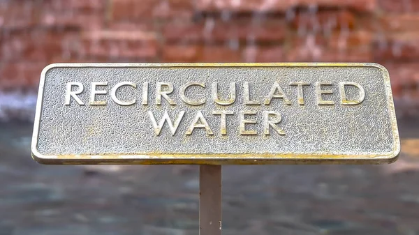 Cadre panoramique Gros plan de la plaque métallique avec des mots Eau recirculée en relief sur la surface — Photo