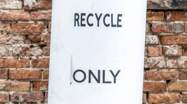 Panorama Bir binanın taş tuğla duvar ve pencerelerine karşı bir çöp kutusu yakın