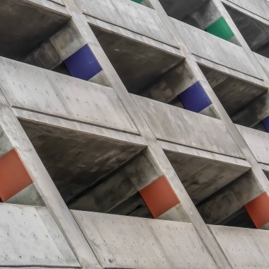 Bulutlu bir günde dışarıdan bakıldığında beton bir binanın Kare çerçeve Kaplı otopark
