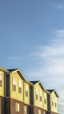 Güneşli bir günde ahşap tuğla ve beton duvar kombinasyonu ile Dikey çerçeve Townhomes