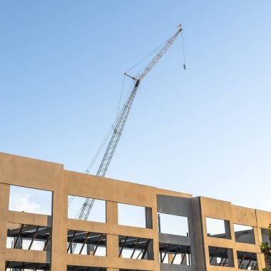 Kare çerçeve Metal çubuklar tarafından desteklenen bitmemiş bir binanın çerçevesi üzerinde Mavi gökyüzü