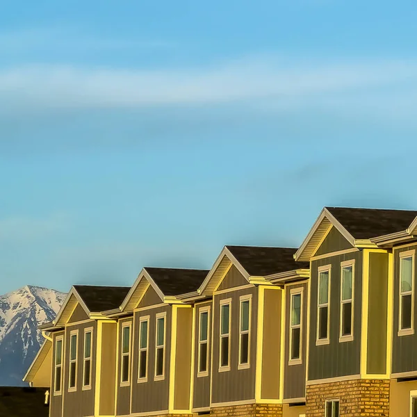 Cielo azul cuadrado sobre casas adosadas de varios pisos con ladrillo de madera y pared exterior de hormigón — Foto de Stock