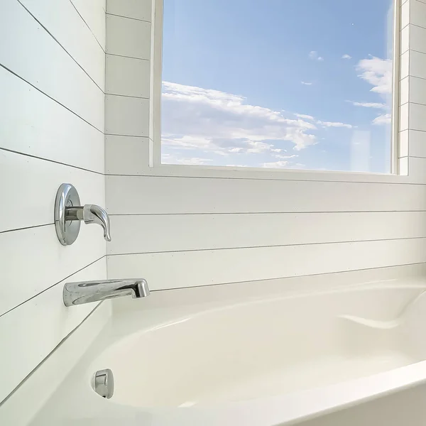 Quadratische minimalistische Badezimmereinrichtung mit weißer Badewanne und weißer Wand — Stockfoto