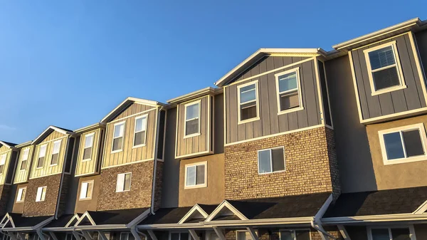 Panorama Townhouses con mattoni in legno e muro di cemento contro il cielo blu in una giornata di sole — Foto Stock