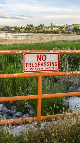 Vertical frame No Trespassing sign on an old metal railing with peeling orange paint — Stock Photo, Image