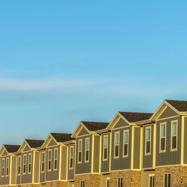 Square Townhomes contra la nieve coronada montaña y el cielo azul brillante en un día soleado — Foto de Stock