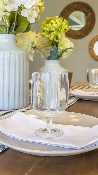 Vertical Dinner setting inside the dining room of a home with mirrors and wall background