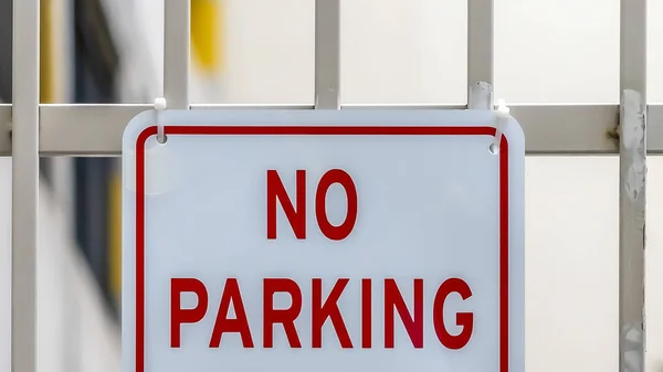 Panorama Cierre de ningún cartel de estacionamiento en una puerta de metal blanco con edificio en el fondo —  Fotos de Stock