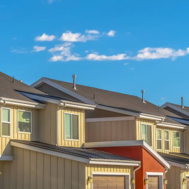 Kare çerçeve Güneşli bir günde mavi gökyüzü ve bulutlara karşı garaj görünümü ile Ev dış