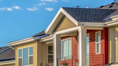 Panoramik Güneşli bir günde gökyüzüne karşı görüntülenen krem ve kırmızı duvarlar ile townhomes Dış