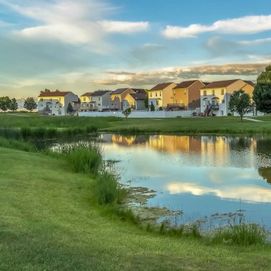 Square Homes ağaçlar ve bulutlu mavi gökyüzü bir gölet yüzeyi gibi aynayansıyan