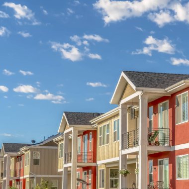 Balkonlu verandalar ve beyaz ve turuncu dış duvar kombinasyonu ile Kare çerçeve Evler