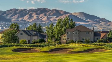 Göl ve dağ manzaralı evlerin önünde Panorama çerçeve Fairway ve golf sahası sığınağı