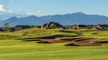 Panorama çerçeve Arka planda konut ve dağ ile bir golf sahası pitoresk görünümü
