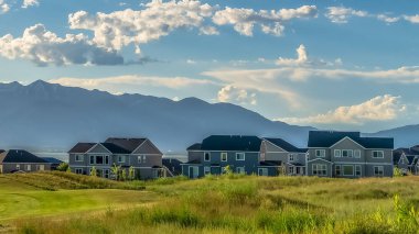 Panorama çerçeve Güneşli bir günde bir göl yakınında bir golf sahası ve yerleşim alanı Lovely görünümü