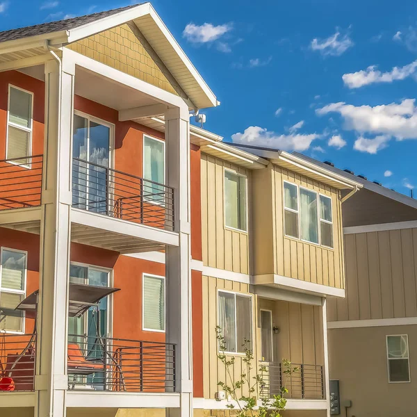 Plaza Exterior de la casa de varios pisos con balcones iluminados por el sol y pared blanca y naranja — Foto de Stock