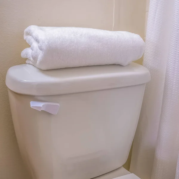 Square Close up of the toilet of a bathroom with a folded towel on top of the tank — Stock Photo, Image