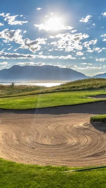 Vertical frame Sand bunker of a golf course and view of bright sun and puffy clouds in the sky — Stock Photo, Image