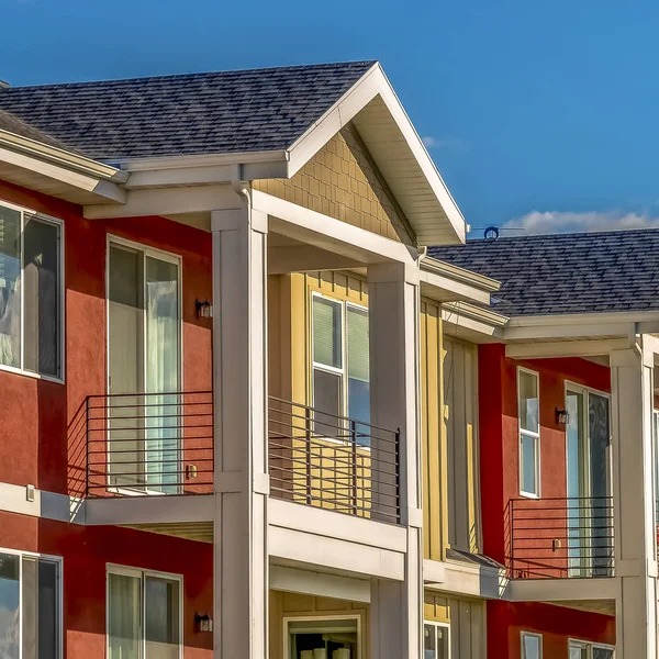 Casas cuadradas con combinación de pared exterior roja y crema contra el cielo en un día soleado — Foto de Stock