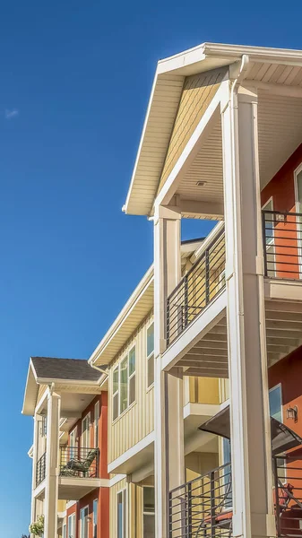 Exterior de la casa vertical con pequeños balcones y combinación de pared blanca y naranja — Foto de Stock