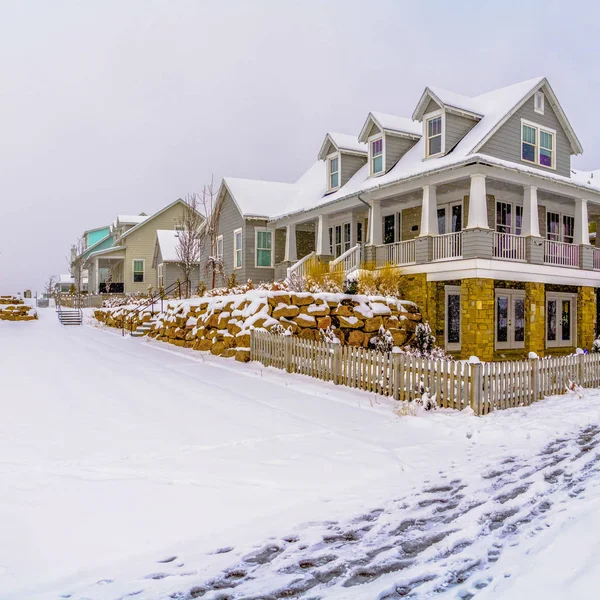 Casas bonitas quadradas cercadas por um terreno gelado sob o céu nublado no inverno — Fotografia de Stock