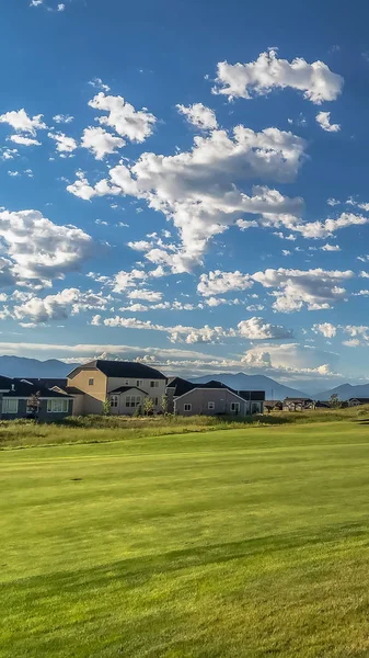 Vertikale Rahmenfairway eines Golfplatzes mit Blick auf Häuser und Berge im Hintergrund — Stockfoto