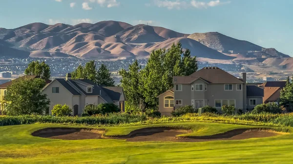 Πανόραμα πλαίσιο και γήπεδο γκολφ μπροστά από τα σπίτια με θέα στη λίμνη και το βουνό — Φωτογραφία Αρχείου