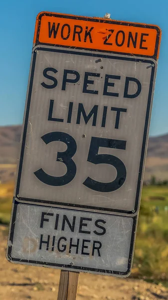 Vertical frame Close up of speed limit sign against dry ground mountain and sky on a sunny day — Stock Photo, Image