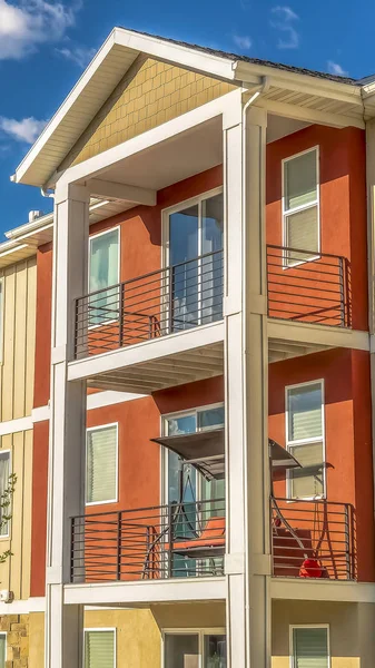 Turuncu ve beyaz dış duvar bölümleri ile çok katlı evlerin dikey çerçeve Cephe