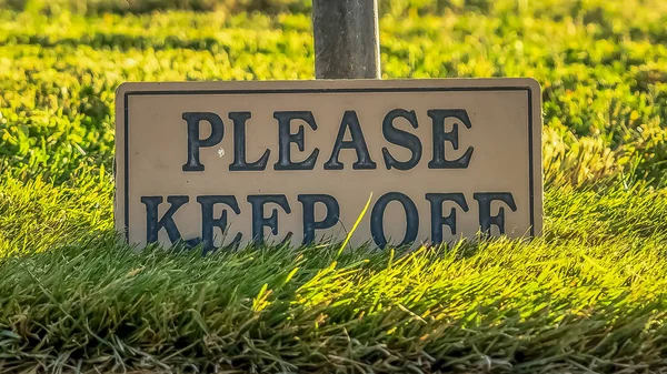 Marco panorámico Por favor, mantenga apagado signo contra hierbas vibrantes y poste de una cerca de alambre — Foto de Stock