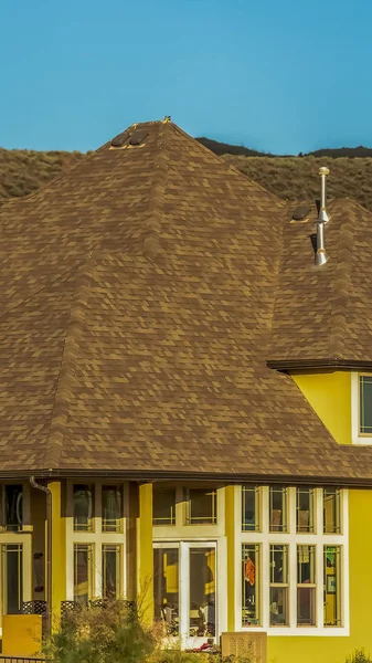 Vertical Home exterior con pared amarilla y techo marrón contra montaña y cielo despejado — Foto de Stock