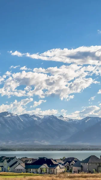 Marco vertical Pintoresco paisaje con casas con vistas a un lago azul y una montaña imponente — Foto de Stock