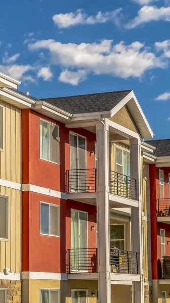 Verticaal kleurrijk huis met combinatie van witte en oranje muur tegen bewolkte blauwe hemel — Stockfoto