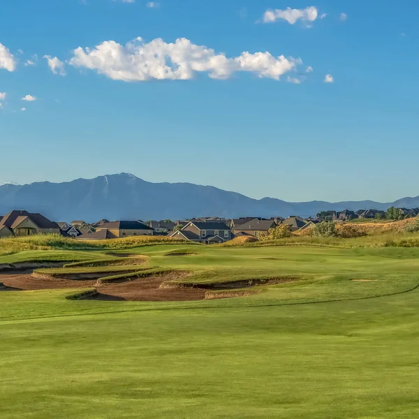 Cadre carré Vue pittoresque d'un terrain de golf avec résidences et montagne en arrière-plan — Photo