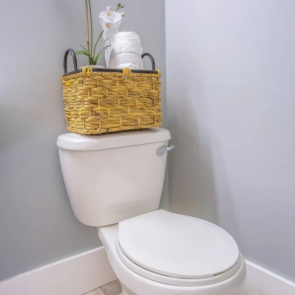 Квадратна рамка Туалет в кутку ванної кімнати з кошиком з ротанга на верхній частині резервуара — стокове фото