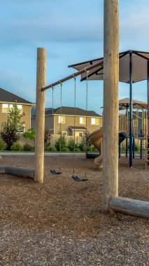 Evlerve bulutlu gökyüzüne karşı slaytlar ve salıncaklar ile Dikey Mahalle oyun alanı