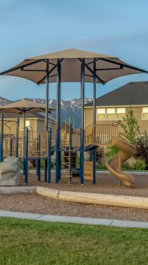 Çok katlı aile evlerinin önünde oyun alanı ve banklar ile Dikey çerçeve Park